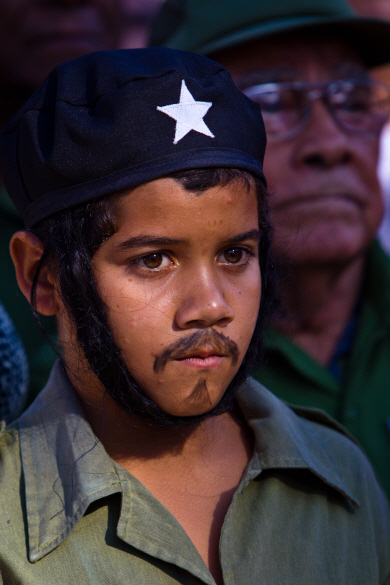 지난 8일 쿠바의 혁명 지도자 체 게바라 복장을 한 소년이 아바나에서 열린 쿠바 혁명 기념행사를 비장한 표정으로 응시하고 있다.   신화통신연합뉴스