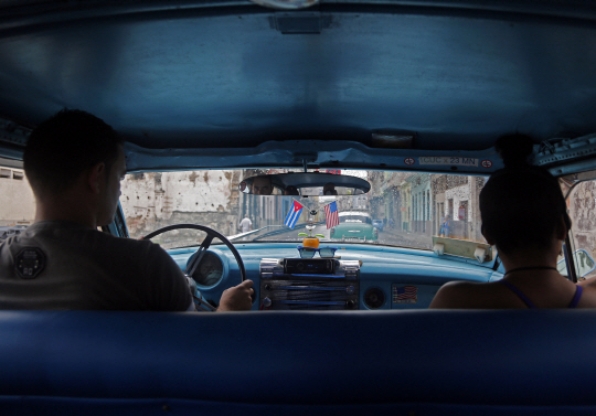 지난해 말 버락 오바마 미국 대통령과 라울 카스트로 쿠바 국가평의회 의장이 관계 정상화 선언을 한 이후 연초부터 양국 간 본격적인 수교협상이 시작되면서 쿠바를 찾는 미국 관광객들이 늘고 있다. 미·쿠바 관계 정상화에 대한 쿠바 시민들의 기대감을 반영한 듯 16일 아바나 거리를 달리는 택시의 앞면 유리 위에 양국 국기가 달려 있다.  AP연합뉴스