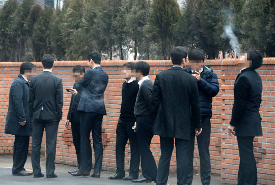 금연구역 확대로 흡연 공간이 대폭 줄어드는 가운데 지난 26일 서울 광화문의 한 빌딩 밀집지역 뒤편 골목에서 회사원들이 모여서 담배를 피우고 있다.