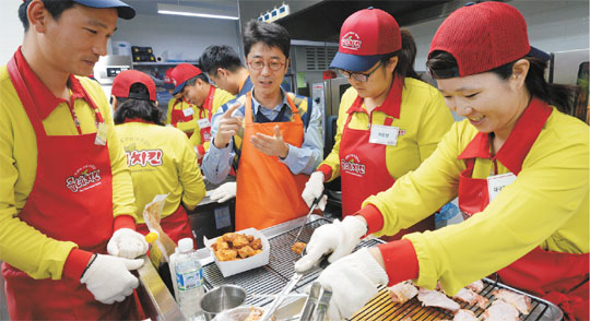 2일 서울 양천구 공항대로 굽네치킨 사옥에서 홍경호(오른쪽 세 번째) 대표가 가맹점주들에게 오븐 치킨의 장점과 고객 응대 경험을 설명하고 있다.