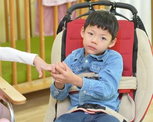 뇌병변장애 2급인 권하늘 군이 산책하러 나가기 위해 휠체어에 앉아 있다.
