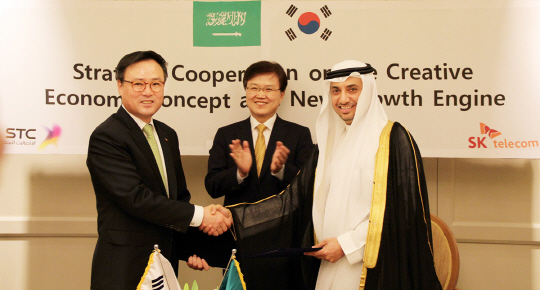 4일(현지시간) 사우디아라비아 리야드 포시즌호텔에서 장동현(왼쪽) SK텔레콤 사장과 에마드 알 아우다흐(오른쪽) 사우디텔레콤 최고경영자 직무대행이 최양희 미래창조과학부 장관이 지켜보는 가운데 상호 협력 협약을 체결한 뒤 악수하고 있다.  SK텔레콤 제공