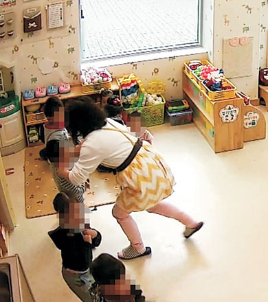 2014년 11월 13일 경남 고성군 고성읍 A 어린이집 교실 CCTV 녹화 영상을 캡처한 사진. 한 보육교사가 원생의 양 볼을 꼬집고 있다.