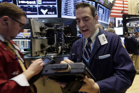 미국 뉴욕 증권거래소에서 16일 거래인들이 주가 상승세에 환한 표정을 지으며 주문을 내고 있다.  AP연합뉴스