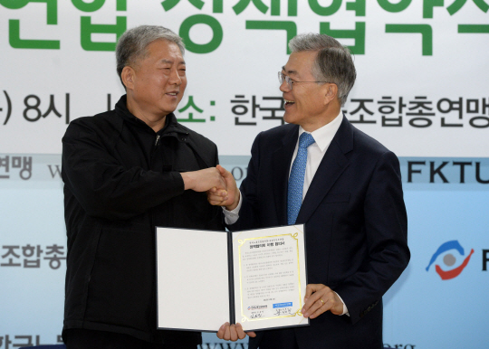문재인(오른쪽) 새정치민주연합 대표와 김동만 한국노총 위원장이 2일 오전 서울 영등포구 여의동 한국노총에서 노동 현안에 대한 정책협약식을 가진 뒤 서명한 협약서를 교환하며 악수를 하고 있다.