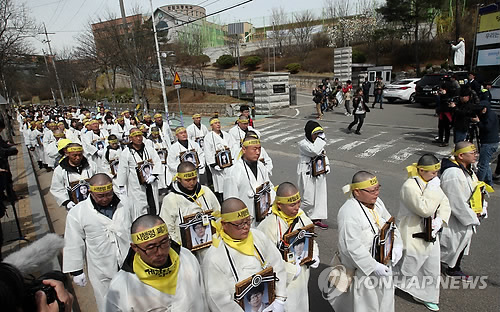 4일 오전 4·16가족협의회의 상복을 입은 세월호 유가족들이 희생자 영정 사진을 들고 진상규명 가로막는 세월호 특별법 시행령안 폐기와 세월호 온전한 인양 결정을 촉구하는 도보행진을 경기도 안산 세월호 희생자 합동분향소에서 시작해 단원고등학교 앞을 지나가고 있다.