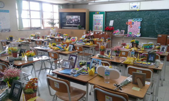 세월호 참사 1주기(16일)를 앞두고 지난 10일 경기 안산시 단원고 2학년 8반 교실 희생자 책상 위에 유가족과 친구들이 두고 간 편지와 꽃 등 추모 물품이 쌓여 있다.