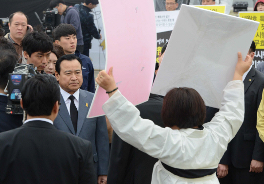 세월호 참사 1주기를 맞은 16일 오전 경기 안산시 초지동 화랑유원지 내 정부합동분향소를 방문한 이완구 국무총리가 조문을 반대하는 유족 앞에서 굳은 표정으로 서 있다.