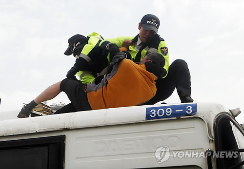 서울 곳곳에서 세월호 관련 집회가 열린 가운데 18일 오후 서울 광화문 누각 앞 버스 위에 올라가 시위를 하던 ‘유민 아빠’ 김영오씨가 경찰에 연행되고 있다. (서울=연합뉴스)