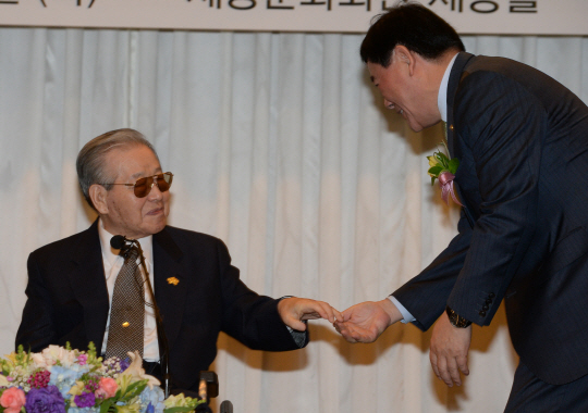 김종필(왼쪽) 전 국무총리가 14일 세종문화회관에서 열린 자신의 화보집 출판기념회에서 최경환 부총리 겸 기획재정부 장관의 인사를 받고 있다.  김선규 기자 ufokim@