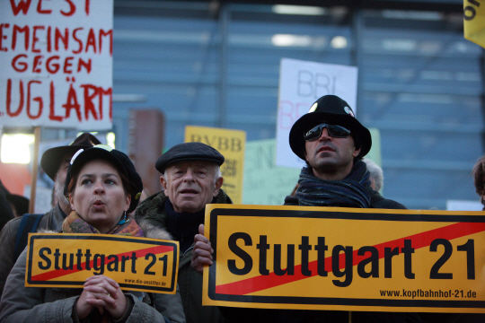 지난 2010년 ‘슈투트가르트21’ 사업을 반대하는 독일 시민들이 노란 팻말을 들고 반대 집회를 벌이고 있다. 아래 사진은 같은 해 갈등 조정 전문가 하이너 가이슬러 및 찬반 입장을 지닌 다양한 이해관계자가 참여한 가운데 열린 중재 회의 모습.  문화일보 자료사진