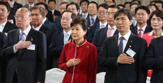 박근혜 대통령과 안희정(오른쪽) 충남지사, 김승연(왼쪽) 한화그룹 회장이 22일 충남 천안에서 열린 충남창조경제혁신센터 출범식에서 국기에 경례하고 있다. 연합뉴스