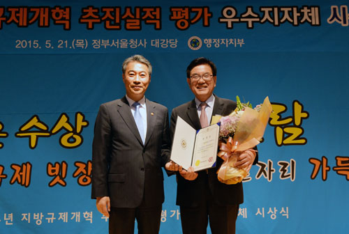 유덕열(오른쪽) 서울 동대문구청장이 21일 ‘지자체 규제개혁 추진실적 평가’에서 우수구로 선정돼 수상한 뒤 정종섭 행정자치부 장관과 함께 기념촬영을 하고 있다. 동대문구 제공