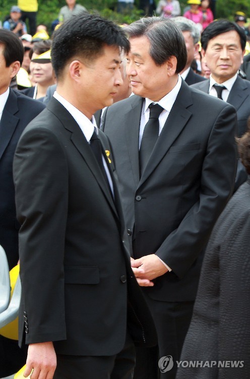 (김해=연합뉴스) 23일 오후 경남 김해시 진영읍 봉하마을 노무현 전 대통령 묘역에서 열린 ‘노무현 대통령 6주기 추도식’에서 굳은 표정의 노건호 씨가 김무성 새누리당 대표를 지나 추도식장으로 입장하고 있다.