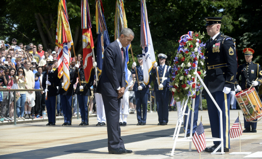버락 오바마 미국 대통령이 25일 미국의 현충일인 메모리얼 데이를 맞아 버지니아 주 알링턴 국립묘지를 찾아 무명용사들 무덤 앞에서 헌화한 뒤 묵념하고 있다. UPI 연합뉴스