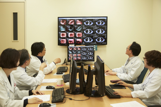 서울아산병원 암 통합진료센터 식도암팀이 암병원 외래 통합진료실에서 환자의 검사자료를 보면서 맞춤형 치료계획을 세우고 있다.  서울아산병원 제공