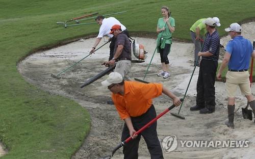 PGA 투어 바이런 넬슨 대회가 폭우로 중단된 뒤 자원 봉사자들이 벙커를 정리하고 있다. (AP=연합뉴스)
