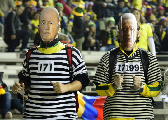 브라질 축구 팬들이 17일 칠레 산티아고에서 열린 2015 코파 아메리카컵 브라질과 콜롬비아 경기에서 제프 블라터(왼쪽) 국제축구연맹 회장과 조제 마리아 마린 전 브라질축구협회장 얼굴 가면을 쓴 채 죄수복을 입고 FIFA 비리를 비판하고 있다.