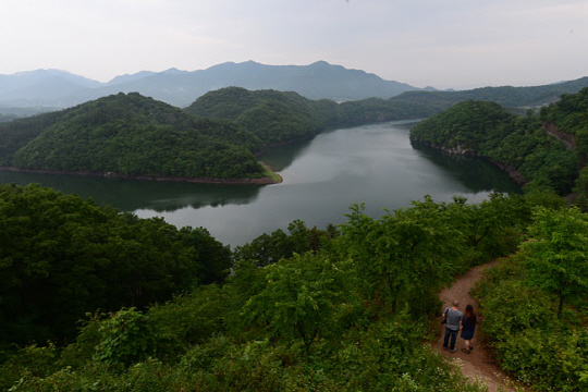 충북 진천군 농암정 위에서 내려다본 초평호. 산과 호수가 어우러져 수려한 자태를 뽐낸다. 오른쪽에 보이는 길은 농암정 위로 오르는 등산로.   신창섭 기자 bluesky@munhwa.com