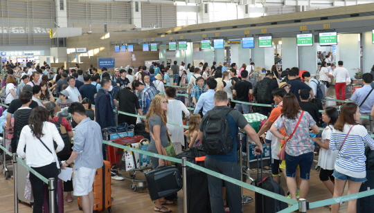 28일 인천국제공항에서 출국을 앞둔 여행객들이 항공기 탑승 수속을 위해 카운터 앞에서 줄을 선 채 기다리고 있다.