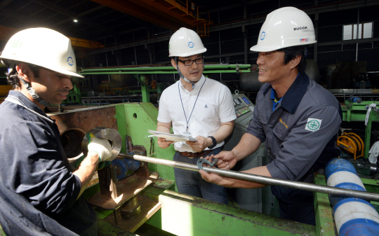 이정민(가운데) 한국생산기술연구원 수석연구원이 29일 부산 강서구 대저로 부곡스텐레스㈜ 공장에서 임직원들과 산학연 협력기술개발사업을 통해 국산 소재 개발에 성공한 ‘스테인리스 육각바’를 살펴보고 있다.