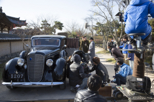 1930년대를 재현한 영화 ‘암살’ 촬영 현장 모습. 1936년식 링컨K 세단을 앞에 놓고 배우들이 연기를 하고 있다. 이 영화 제작사는 이 차를 비롯해 총 4대의 클래식카를 미국에서 직접 구입해 왔다.