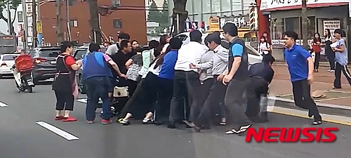 【창원=뉴시스】지난 3일 오후 6시35분께 경남 창원시 마산회원구 마산역 사거리에서 A(52·여)씨가 몰던 BMW차량이 B(17·고2)양을 덮치는 사고가 발생하자 이를 목격한 남녀 시민 20여 명이 차량을 들어 올려 B양을 구조하고 있다. (사진= 경남지방경찰청 제공 영상 캡처)