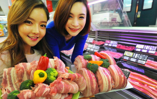 홈플러스가 ‘바캉스 시즌’을 맞아 연중 최대 규모의 ‘돈육(돼지고기) 페스티벌’을 전개하고 있는 가운데 홈플러스 영등포점에서 모델들이 국내산 삼겹살을 선보이고 있다.  홈플러스 제공