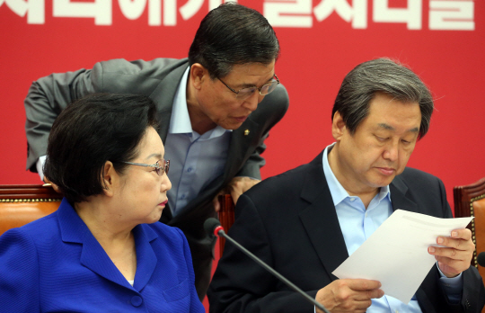새누리당 김무성(오른쪽) 대표가 5일 오전 국회에서 열린 최고위원·중진의원연석회의에서 회의 도중 황진하(가운데) 사무총장으로부터 받은 보고 자료를 읽고 있다. 연합뉴스