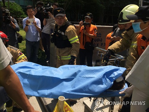 12일 오후 서울 종로구 주한 일본대사관 앞에서 열린 수요집회에서 분신을 시도한 한 남성이 병원으로 이송되고 있다. (서울=연합뉴스)