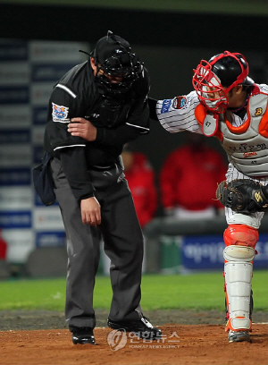 경기 도중 파울타구에 팔뚝을 얻어맞은 심판이 괴로워하고 있다.