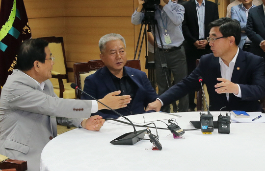 김대환(왼쪽) 경제사회발전노사정위원장과 이기권(오른쪽) 고용노동부 장관이 8일 정부서울청사 노사정위에서 열린 4인 대표자 회의에서 발언 순서를 서로 양보하고 있다. 가운데는 김동만 한국노총 위원장. 연합뉴스