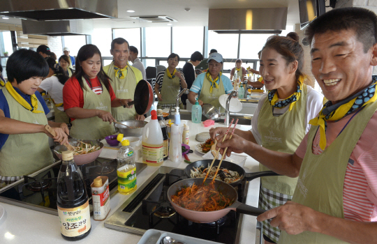 지난 8월 21일 서울 서대문구 이화여대 인근의 라니요리교실에서 농촌사랑지도자연수원이 진행하는 ‘다문화가정 농촌정착지원’ 프로그램에 참여한 가족들이 오삼불고기 등 요리를 만들며 밝게 웃고 있다.