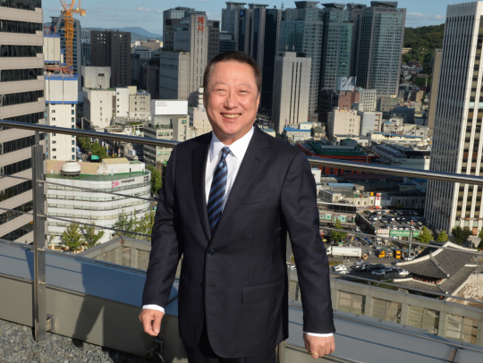 박용만 회장이 회원사 빌딩들이 보이는 대한상의 옥상 정원에서 포즈를 취하고 있다.