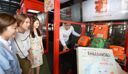 21일 오전 서울 종로구 세종로 KT 광화문 올레스퀘어에서 개최된 ‘대한민국 통신 130년 특별전시회’에서 관람객들이 옛날 공중전화기를 보며 신기해 하고 있다.  정하종 기자 maloo@