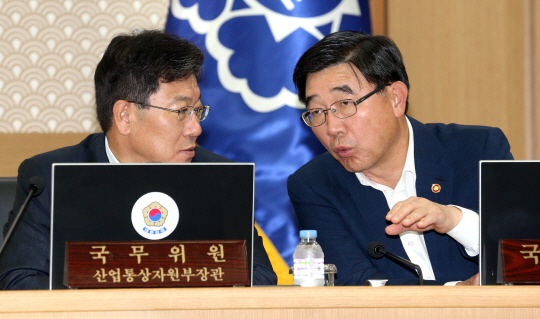 윤상직(왼쪽) 산업통상자원부 장관과 이기권 고용노동부 장관이 30일 정부세종청사 회의장에서 정부서울청사와 연결한 영상 국무회의에 앞서 얘기를 나누고 있다. 연합뉴스