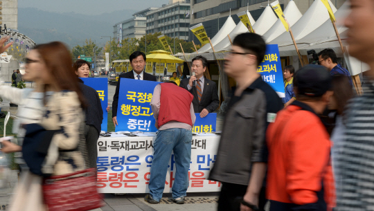 새정치민주연합 소속 의원들이 19일 서울 광화문광장 이순신 동상 앞에서 국정교과서 반대 서명운동을 진행하고 있다.