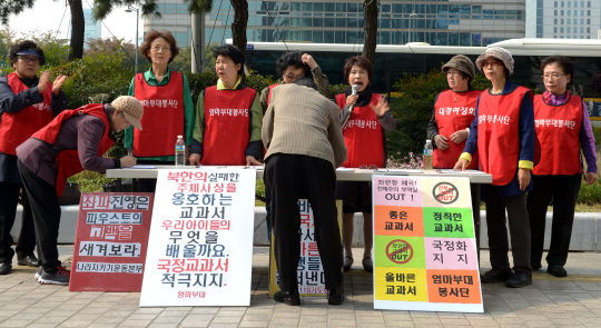 ‘엄마부대봉사단’을 비롯한 보수단체 회원들이 19일 서울 광화문 일민미술관 앞에서 국정교과서 찬성 서명운동을 전개하고 있다.