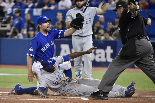 캔자스시티 로열스의 로렌조 케인(아래)이 21일(한국시간) 캐나다 온타리오주 토론토의 로저스 센터에서 열린 아메리칸리그 챔피언십시리즈 4차전 1회 상대 투수 RA 디키의 폭투 때 홈에서 세이프되고 있다.