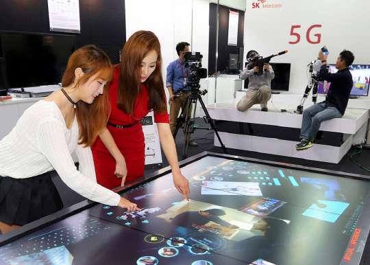 29일 경기 성남시 분당구 SK텔레콤 종합기술원 내에 문을 연 ‘5G 글로벌 혁신센터’에서 모델들이 SK텔레콤과 성균관대 박사과정 학생들이 개발 중인 컴퓨터 기기 ‘테이블탑’을 시연하고 있다.