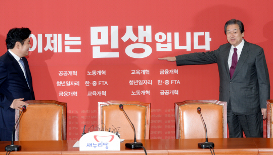 5일 국회에서 열린 새누리당 최고위원회의에서 김무성(오른쪽) 대표가 회의에서 새로 선택한 ‘이제는 민생입니다’라는 슬로건을 소개하고 있다. 왼쪽은 원유철 원내대표.