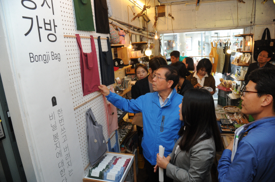 일자리 대장정에 나선 박원순(왼쪽) 서울시장이 지난 10월 21일 총 250여 명의 디자이너가 만든 업사이클 제품을 판매하는 홍대 편집매장인 ‘오브젝트 생활연구소’에서 환경을 고려한 제품인 가방을 살펴보고 있다.
