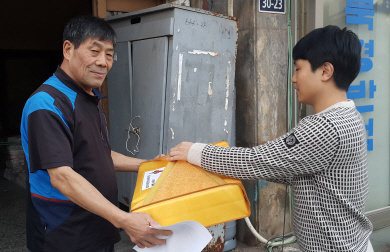 서울 동대문구 사회복지협의회 관계자(오른쪽)가 지난 5일 지역 내 쪽방촌 주민에게 고향방문 열차표와 곶감선물 세트를 전달하고 있다.  동대문구 제공