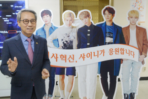 이근면 인사혁신처장이 16일 정부서울청사 15층 복도에 설치된 인사혁신처 홍보대사 샤이니 입간판 옆에서 포즈를 취하고 있다.  김낙중 기자