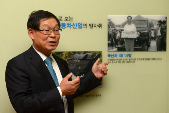 김용근 회장이 지난 2일 자동차회관 로비에 전시된 초창기 국산차 사진들에 대해 설명하고 있다. 김호웅 기자