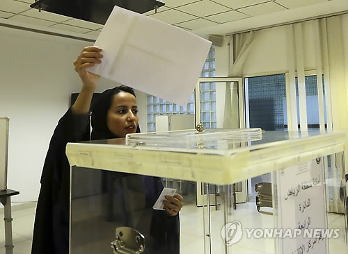 (리야드 AP=연합뉴스) 사우디아라비아에서 여성에게 처음 참정권을 부여한 역사적인 지방선거 투표가 실시된 지난 12일(이하 현지시간) 리야드의 투표소에서 한 여성 유권자가 투표함에 투표용지를 넣고 있다.