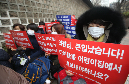 서울시 가정·국공립·민간 어린이집 연합회 회원들이 14일 서울 중구 서울시청 서소문별관 앞에서 손 피켓을 들고 ‘어린이집 누리과정 예산편성 촉구대회’ 시위를 하고 있다. 연합뉴스