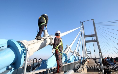 낙뢰로 추정되는 화재가 발생해 끊어진 서해대교 72번 케이블 교체 작업이 17일 완료됐다. 현장 관계자들이 케이블 연결 마무리 작업을 진행하는 모습.