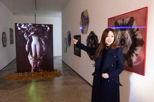 마리 킴이 캐릭터 ‘아이돌’이 우주복 차림으로 등장하는 영상물 ‘Doomed Planet’에 대해 설명하고 있다.
