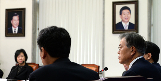 문재인(오른쪽) 더불어민주당 대표가 13일 국회에서 열린 최고위원회의에서 참석자들의 발언을 듣고 있다. 의원들의 잇단 탈당으로 더민주가 광주에서 제1당 자리를 국민의당에 넘겨준 상황이어서 회의실에 나란히 걸려있는 김대중·노무현 전 대통령의 사진이 어색하게 느껴진다.
